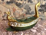 un bateau doré et vert posé sur une surface de marbre