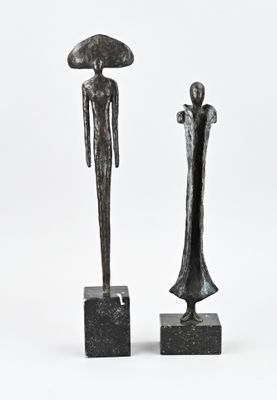 two sculptures of a man and a woman standing next to each other