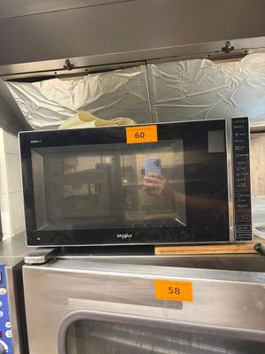 un micro-ondes posé sur une cuisinière dans un magasin