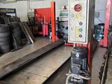 une photo d'un garage où l'on voit de nombreux pneus par terre