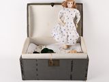 a doll that is sitting inside of a suitcase