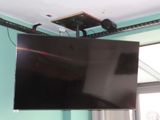 un téléviseur à écran plat suspendu au plafond dans une pièce