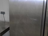 a silver refrigerator in the corner of a kitchen
