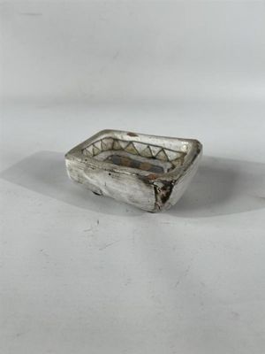 une image représentant une petite assiette en argent posée sur une surface blanche