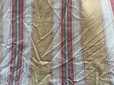 a close up of a bed with a striped comforter on it
