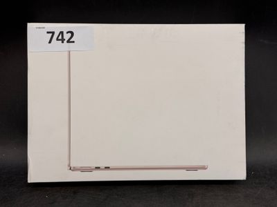 un ordinateur portable Apple posé sur une boîte blanche