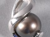 a silver ring with a brown pearl on it
