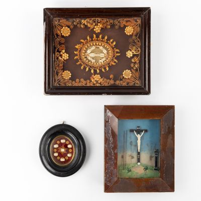 two framed pictures of a crucif and a clock on a wall