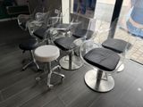 plusieurs chaises et tabourets transparents dans une pièce dotée d'une grande fenêtre