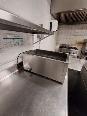 plan de travail en acier inoxydable dans une cuisine commerciale équipée d'appareils en acier inoxydable