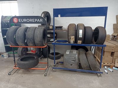 de nombreux pneus empilés sur un support dans un garage