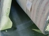un rouleau de moquette posé par terre, muni d'une étiquette