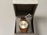 Une montre Michael Korsch dans son coffret, posée sur une table blanche