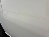 a close up of a white car with scratches on the side