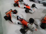 quatre voitures de course exposées sur un fond blanc
