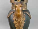 a statue of a woman holding a vase on a stand
