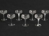 six wine glasses are lined up in a row on a black background