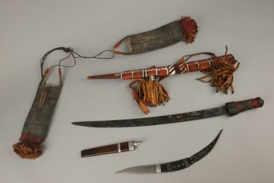 plusieurs types de couteaux et d'autres objets exposés sur une table