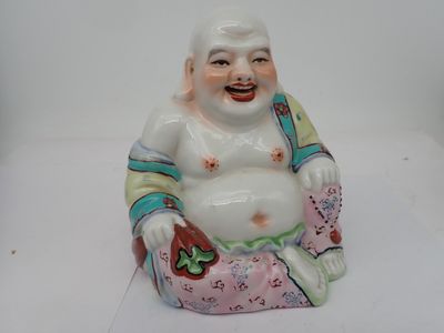 une figurine représentant un Bouddha rieur assis par terre