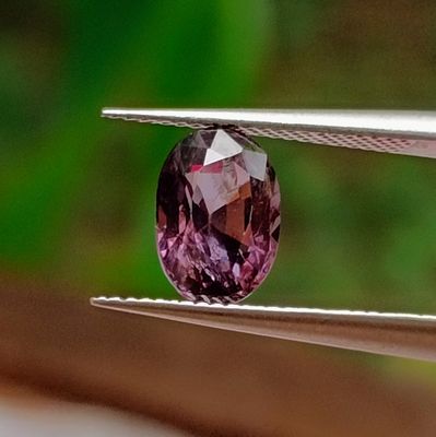 someone is holding a pair of pliers with a purple diamond on it