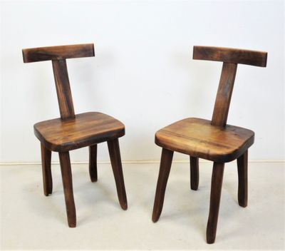 two wooden chairs sitting next to each other on a white floor