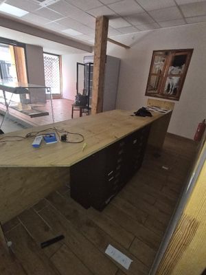 une photo d'un bureau avec un bureau et une grande fenêtre