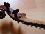 a close up of a violin on a wooden table