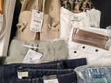 many pairs of shoes and bags on display in a store