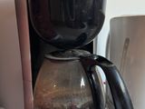 a coffee maker that is on top of a microwave