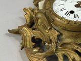 a gold clock that is sitting on a white table