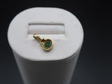 a close up of a small green stone in a white ring