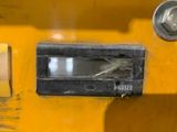a small bird that is sitting on the side of a yellow machine