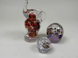 three glass figurines of elephants and a glass ball