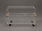 a clear acrylic and brass bar cart with wheels