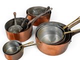 several pots and pans are lined up on a white surface