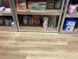 un sol en bois dans un magasin dont les rayons regorgent de jouets