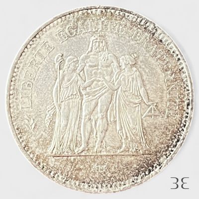 une image représentant une pièce d'argent sur laquelle figurent une femme et deux hommes