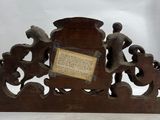 an old wooden clock with a plaque on it sitting on top of a table