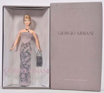 une poupée Barbie dans une boîte contenant un sac à main