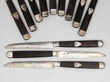 several knives are lined up next to each other on a table