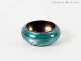 a small blue vase with a gold rim on a white surface