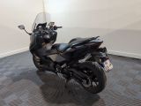 a black motorcycle parked in a room with a checkered floor