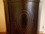 a black cabinet with a marble top on a wooden floor