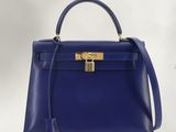 un sac à main bleu muni d'un fermoir doré sur la poignée