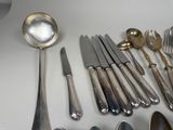 a lot of silver spoons and spoons on the table