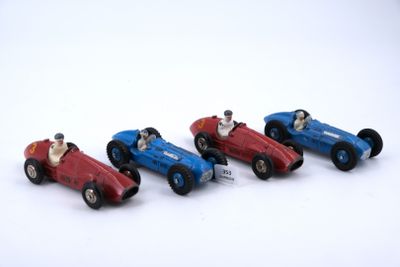 four toy cars that are lined up on a white surface