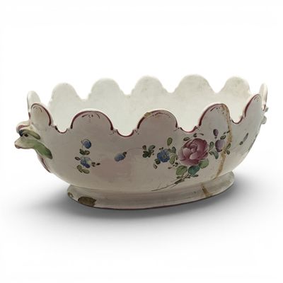 a white bowl with flowers on it on a white surface