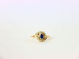 une bague en or jaune sertie d'un saphir entouré de diamants