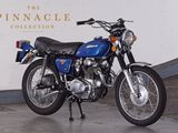 a blue motorcycle parked in front of the pinnacle collection sign