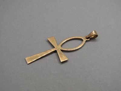 une image représentant un poisson rouge et un pendentif en forme de croix sur un fond gris